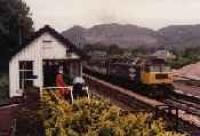 Class 47 hauled passenger train running south through Dunkeld station. View looking north from the former locomotive shed showing the signalbox.<br><br>[Ewan Crawford //]