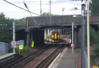 Photograph taken looking north west from the footbridge at Whifflet station in August 2006. A train for Glasgow Central has just left the platform and passed under the bridge carrying Whifflet Street (A725). The train is turning west at Whifflet North Junction heading for its next stop at Kirkwood.<br><br>[John Furnevel 24/08/2006]