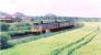 SPTE 107 passing Carmuirs housing scheme. Train from Glasgow to Falkirk via Lenzie. The three bings are near Roughcastle.<br><br>[Brian Forbes 02/05/1987]