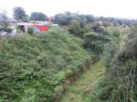 View south from the bridge over the trackbed at Tynehead in August 2002 showing the steep climb away from the platforms immediately below the bridge. The former station building and goods yard are on the left with the trackbed of the spur running north off the main line to reach the yard visible in the background. <br>
<br><br>[John Furnevel 12/08/2002]