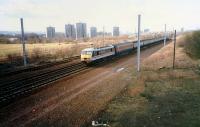 A brand new Class 90 passes Shieldmuir heading south. On a test run the locomotive and rake had come up the WCML, passed round the junctions at Mossend and was now heading south. This is now the site of Shieldmuir station.<br><br>[Ewan Crawford //1989]