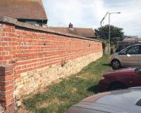 All that remains of Seahouses station on the North Sunderland Light Railway in the summer of 2007 - the lower (lighter brick) section of the wall alongside the village car park once formed part of the platform face. [See image 41104]<br><br>[John Furnevel 18/08/2007]
