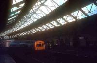 A DMU for Newcastle Central stands under the overall roof of the 1879 station at South Shields in the 1970s. As with a number of previous stations serving the town (the first being the Stanhope & Tyne in 1835) this one is no more. Today South Shields is served by a modern Tyne & Wear Metro station located a short distance to the west of this spot and opened in March 1984.<br><br>[Ian Dinmore //]