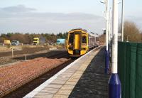 An Edinburgh - Bathgate service pulls into the platform at Uphall on 15 February 2008 as traffic continues west along the M8. Note the area now pegged around the site of the second platform as well as the work underway beyond in preparation for new infrastructure on the north side of the station.<br><br>[John Furnevel 15/02/2008]