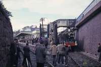 J37 No 64569 meets a photographic scrum at the south end of St Andrews station during the 1965 RCTS <I>Fife Coast railtour</I>. The J37 had taken over from No 256 <I>Glen Douglas</I> at Leuchars Junction and took the train round the Fife Coast line before handing back to no 256 at Thornton Junction.<br><br>[G W Robin 28/08/1965]