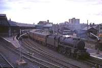 A busy scene at Perth in August 1965 as Stanier Black 5 No 44718 pulls in with a Dundee - Glasgow train while a down service boards at the opposite platform. A type 2 diesel locomotive is standing between the trains on the centre road.<br><br>[G W Robin 28/08/1965]