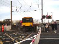 A failure of the barrier system at Stevenston results in 318 269 being flagged over the crossing against a danger signal on 12 November with a service for Ardrossan Town.<br><br>[David Panton 12/11/2008]