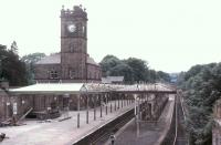 Ulverston station was built by the Furness Railway to replace the Ulverston and Lancaster Railway station and its own nearby terminus thereby providing a proper through station that could also act as a junction for the Lakeside branch. In 1981 when this picture was taken the station canopies were very much under threat but thankfully later saved. [See image 22161] for a modern day comparison. View west towards Barrow-in-Furness.<br><br>[Mark Bartlett 28/06/1981]