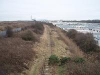 View south from the end of the rails on the former Fleetwood line towards Burn Naze, where the industrial complex that kept the southern section of the line open for freight until the 1990s can be seen. Right up to the 1960s this then double track line saw express fish trains to London as well as a variety of other traffic. Passenger services ceased in 1970. Map Ref SD 329455<br><br>[Mark Bartlett 17/02/2009]
