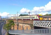 A westbound EMU heads for Partick on the urban viaduct alongside the Clydeside Expressway at Queens Dock on 10 May 2009. <br>
<br><br>[Colin Miller 10/05/2009]