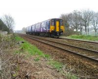 150223 heads west towards Southport on a service from Manchester Victoria on 3 April 2009. The train has just left Burscough Bridge station which can be seen in the distance. <br>
<br><br>[John McIntyre 03/04/2009]