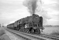 BR Standard Class 9F no 92064, carrying a 52H, Tyne Dock, shedplate, photographed near Pelton in the 1960s en route to Consett steel works with a trainload of imported iron ore. The train has recently picked up a banking locomotive at South Pelaw. Note the Westinghouse pumps for operating the hopper doors, fitted to all ten of the 9Fs based at Tyne Dock.<br><br>[Robin Barbour Collection (Courtesy Bruce McCartney) //]