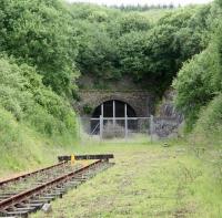 Located approximately 12 miles south of Hawick, between Shankend and Riccarton Junction, is the 1,208 yard Whitrope Tunnel, the south portal of which is seen here on 10 July 2009. The tunnel, noted as Scotland's fourth longest, is currently a listed structure (Category B). The rails in the photograph represent the northern extent of the relaying undertaken by the Waverley Route Heritage Association, whose volunteers have carried out considerable work associated with the tunnel and the Whitrope site in general. The WRHA centre and car park is located alongside the B6399 road just to the south of this point. [See image 32810]<br>
<br><br>[John Furnevel 10/07/2009]