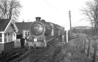 Class J37 0-6-0 no 64587 pauses on the crossing alongside Rosslynlee station on 3 February 1962 on its way south with the <i>Farewell to Peebles</I> railtour over the Peebles loop. The line was closed to passenger traffic south of Hawthornden Junction two days later. District Operating Inspector David G Kerr, who accompanied many of these specials, is standing on the left of the picture with his back to the crossing gates. <br><br>[K A Gray 03/02/1962]