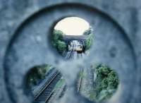 A DMU approaches Great Malvern from the Birmingham direction in 1988. Seen through the decorative stone parapet on the road bridge.<br><br>[Ken Strachan //1988]