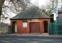 A public toilet block on Colinton Road, Edinburgh, photographed on 27 November 2009. The building, recently saved from demolition (notice the new flats currently under construction on the right), was originally a tram ticket office standing alongside the Colinton terminus of the no 9 and no 10 tram routes [see image 26504]. The ticket/enquiry counter was behind the double doors. The building is thought to be the last of its type and is now listed as being of historical importance.<br>
<br><br>[John Furnevel 27/11/2009]