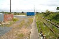 View east from Stranraer Town station in May 2007, some 41 years after closure. To the left  stood a large goods yard and locomotive shed, the surviving building of which can be seen in the centre background behind the blue container. Beyond the shed a large scrapyard occupies the 'V' between this route and the Harbour branch, which turns north west just around the curve at Stranraer Harbour Junction. Behind the camera the line once continued to Portpatrick, the last remnants of this section having been closed completely in 1959 [see image 15539].<br>
<br><br>[John Furnevel 31/05/2007]