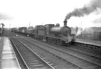 J36 0-6-0 no 65303 pulls up at Inverurie with a freight in March 1959. Immediately behind the J36 is Barclay diesel-hydraulic no D2414, at that time a recent addition to the allocation of Keith shed.<br><br>[Robin Barbour Collection (Courtesy Bruce McCartney) 26/03/1959]