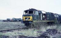 Two Hymek Class 35s and a North British Class 22 await the inevitable in Swindon Works yard in 1972. The NBL Class 22 is in early rail blue with a half yellow panel and engineless although the flat wagon next to it appears to be carrying a power unit under the tarpaulin. The green Hymek has already lost its engine and the roofless early blue specimen behind is in an equally sorry state. My records from the time indicate that the Class 22 was D6322 and the green Hymek is D7024.  <br><br>[Mark Bartlett 18/03/1972]