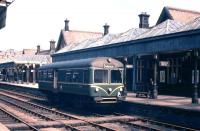 The mid-day departure for Gleneagles prepares to leave Crieff's grand and capacious station in the early summer of 1961 (once someone closes the track-side door). If ever a line which was soon to face the Beeching Axe had options for sensible cost rationalisation to avoid closure, then this was it - too many buildings, extensive platform awnings, three tracks through the station, complex signalling - all for a 'one train working' railbus service and a couple of freight trains daily. The Beeching Report actually highlighted the Gleneagles-Crieff/Comrie service as a case study, and the statistics showed that it was the track and signalling costs which killed the service. If a Crieff-Gleneagles 'basic railway' had clung on, doubtless we would now be enjoying an hourly Crieff-Glasgow service!<br><br>[Frank Spaven Collection (Courtesy David Spaven) //1961]