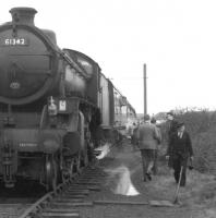 'See when I say <I>get back on the train</I>....'  The persuasive looking gentleman moving threateningly towards the photographer appears keen to commence the next leg of the <I>Scottish Rambler No 5</I> railtour which is preparing to leave Girvan goods behind B1 no 61342 on 10 April 1966.... and what's that in his left hand...no, surely not!  Anyway... I understand everyone got back on the train at this point. <br>
<br><br>[K A Gray 10/04/1966]