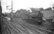 Photograph taken from a train passing south through Alnmouth station on 13 August 1960. Alnmouth was the junction for the Alnwick branch and possessed a 2-road locomotive shed (sub to 52D Tweedmouth - closed June 1966) standing in the centre background. The locomotive in the picture is Heaton based J39 0-6-0 no 64945.<br><br>[Robin Barbour Collection (Courtesy Bruce McCartney) 13/08/1960]