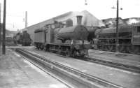 Shed scene at Trafford Park (9E), Manchester, on 21 June 1958, with class J10 no 65166 centre stage and Black 5 no 45239 standing on the right. Trafford Park closed to steam in 1968 and the shed was demolished in the mid 1970s. A large Freightliner depot was later built on the site. <br>
<br><br>[Robin Barbour Collection (Courtesy Bruce McCartney) 21/06/1958]