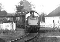 A coal train from Dollar passing over the A908 level crossing and about to run through the abandoned platforms of the former Tillicoultry station in the autumn of 1971. The train is on its way to the yards at Alloa with coal for Kincardine power station. [See image 18238]<br><br>[John Furnevel 07/10/1971]