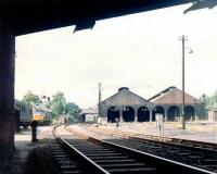 The shell of Dumfries shed on a quiet Sunday in June 1969. View north through Annan Road Bridge with the station in the background. The type 2 diesel stabled alongside the old goods depot is probably diagrammed for the first ICI working from Cargenbridge on Monday morning.<br><br>[John Furnevel 22/06/1969]