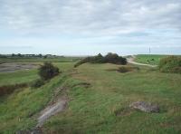 A branch of the Carnforth Ironworks tramroad was used for tipping slag alongside the Keer estuary. The old slag heaps have now been incorporated into a local landfill site but parts of them are still visible as is this section of the old formation looking south alongside the River Keer estuary towards the sea. Map Reference SD 486714<br><br>[Mark Bartlett 27/08/2010]