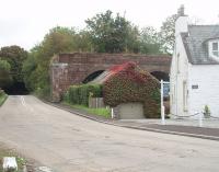 Part of the surviving remnants of Tongland Viaduct are seen here behind a house alongside the A711 road. The road crosses the River Dee running parralel to the old Kirkcudbright railway but then swings sharp right to pass under the line although the road bridge has been removed since the line closed in 1965. <br><br>[Mark Bartlett 19/09/2010]