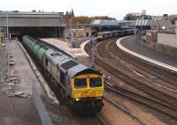<I>Fastline</I> liveried 66434 heading south through Perth station on 11 October 2010 with the return Lairg oil tanks. A DMU stands at the Dundee platform in the background while repair and refurbishment work continues on platform 4.<br><br>[Brian Forbes 11/10/2010]