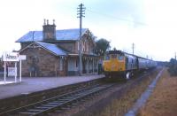 Bunting in evidence as a Class 24-hauled train for Inverness calls at Alness on the first day of service following the station's re-opening in May 1973. Sadly, the attractive Highland Railway station building has since been demolished.<br><br>[David Spaven 07/05/1973]