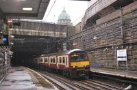 320313 emerges from below the M8 at Charing Cross on 15 March with an eastbound service. The dome of the Mitchell Library dominates the skyline.<br><br>[Bill Roberton 15/03/2011]