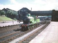 Running through the middle road at Dumfries on 13 June 1959 is ex-Great North of Scotland Railway 4-4-0 No 49 <I>Gordon Highlander</I>. The locomotive has just arrived back in the station following a visit to Dumfries shed for refreshment, having earlier brought in the SLS <I>Golden Jubilee Special</I> from Buchanan Street. No 49 will shortly rejoin the train for the return journey to Glasgow, where the railtour will terminate at St Enoch station. The top of Dumfries shed can be seen in the left background on the south side of St Mary's Street road bridge. [See image 30151]<br><br>[A Snapper (Courtesy Bruce McCartney) /06/1959]