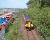 Only a short distance for 156449 to go before reaching Stranraer Harbour as it passes over the disused connection to the Stranraer Town freight facilities. Former railway land to the left of the train is now in other use and Town station is just beyond the white lorry at the end of the yard. Picture taken from overbridge at NX 073604.  <br><br>[Mark Bartlett 23/05/2011]