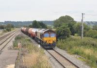 DBS 66013 with a westbound tanker train runs through Pilning station, South Gloucestershire, on 12 July 2011 heading for the Severn Tunnel.<br><br>[Peter Todd 12/07/2011]