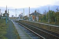 A plethora of poles characterized the station at Westerfield on 26th November 1977 - the station lighting was being upgraded. This was the view east towards the junction with the Felixstowe branch. The manual level crossing gates in the picture were retained for another 13 years.<br><br>[Mark Dufton 26/11/1977]