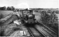 CMHW No.2, a Barclay 0-4-2ST, approaches the hospital station at Whittingham with a train from Grimsargh running along the ash embankment within the hospital grounds. The train consists of three converted LNWR brakevans that were the passenger stock in later years. The photograph dates from prior to 1952 when No 2 was withdrawn and later replaced by the Sentinel locomotive 'Gradwell'. [See image 35479] for the same location in 2011.<br><br>[David Hindle Collection //]