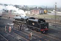 After visiting Ravenglass on 9 May 1970, Scottish Grand Tour No. 10 retraced its steps to Carnforth, where enthusiasts were able to visit Steamtown. Photograph taken from the footbridge giving access off Warton Road, showing preserved Black 5 No. 44871 in steam in the shed yard. [Railscot note: By coincidence the young man in the brown coat to the left of the small  group alongside the cab is Railscot contributor Jim Peebles!]  <br><br>[Bill Jamieson 09/05/1970]