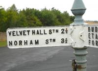 A remote crossroads in Northumberland, in 2006. The recently painted sign directs the motorist back in time to Velvet Hall Station closed 1955) and Norham Station (closed 1964). The line from Tweedsmouth to Kelso closed completely in 1965. [See image 37085]<br><br>[Brian Taylor //2006]