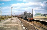 Looking north from the down platform at Symington station on a fine spring day in April 1959. A WCML express is about to run south through the station, double headed by Black 5 no 44952 and Royal Scot no 46104 <I>Scottish Borderer</I>.<br><br>[A Snapper (Courtesy Bruce McCartney) 04/04/1959]