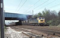 Brush Class 47 47350 takes a rake of MGR hoppers under the M6 Motorway on the Up Fast line at Euxton Junction in 1981. The loco later became Freightliner Class 57 57005 and (as at April 2012) is presently in store at Carnforth [See image 36155]. <br><br>[Mark Bartlett 27/04/1981]