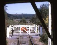 A member of the train crew opens the crossing gates between Staverton and Totnes on 30 July 1969 on what was then the Dart Valley Railway. The view is from the front of the Auto coach of the train in which the locomotive, an ex GWR 0-6-0 Pannier Tank, was sandwiched between 4 coaches.<br><br>[John McIntyre 30/07/1969]