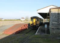 ATW single unit 153320 waits at the Pembroke Dock branch terminus prior to returning to Carmarthen and Swansea, as seen from the buffer stops. Can anyone advise what sort of traffic the ramp on the disused platform line was used for?<br><br>[Mark Bartlett 23/03/2012]