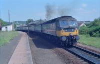 47642 leaves Forres with an Aberdeen-Inverness train on a sweltering day in the summer of 1990. This was during the period when Sprinters were withdrawn not long after their introduction. The former Perth platform was to the right of the locomotive. The photograph is taken from the former eastbound (Inverness to Aberdeen) platform.<br><br>[Ewan Crawford //1990]