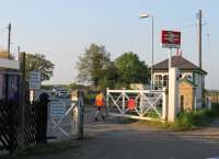 The signalman at Swinderby station manually opens the level crossing gates after an oil train from Immingham has passed through. The busy road is narrow at this point but the distance between the two gates is substantial leading to an unusual arrangement when the crossing is open to road traffic. [See image 16453]<br><br>[Mark Bartlett 22/05/2012]