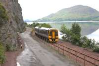 Loch Carron is <I>mill pond smooth</I> at high tide as 158715 approaches the avalanche shelter near Attadale. The train is running on the reclaimed land which pushed the railway further out into the loch when the road was built between it and the cliff face in the 1960s. <br><br>[Mark Bartlett 11/07/2012]