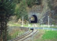 Le Tunnel de Besse, 110 metres long, lies between Saint Sauveur la Sagne and Saint Alyre d'Arlanc on the AGRIVAP tourist line in the Auvergne region. Usually a big hit with passengers pulled along in an open wagon behind the line's heritage Panoramique railcar X4208, the tunnel is seen here pre-season on a quiet Saturday morning over the level crossing of the D38 road.<br><br>[Andrew Wilson 28/04/2012]