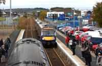 Class 170s cross at Dyce on 19 October 2012. On the left is a service for Inverness while approaching on the right is a service to Edinburgh. Raiths Farm yard is beyond the overbridge in the background and to the left of the running line.<br><br>[John McIntyre 19/10/2012]